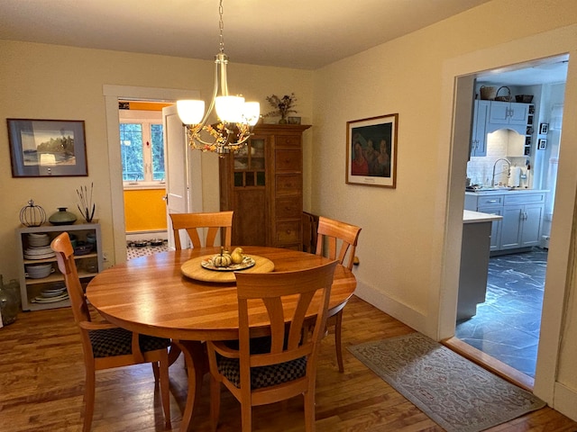 dining space featuring an inviting chandelier, sink, and dark hardwood / wood-style flooring