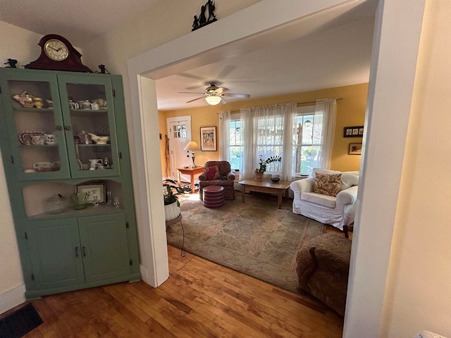 living room with wood-type flooring and ceiling fan