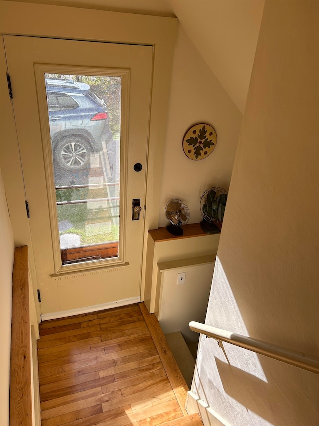 doorway to outside with vaulted ceiling, light wood-type flooring, and a wealth of natural light