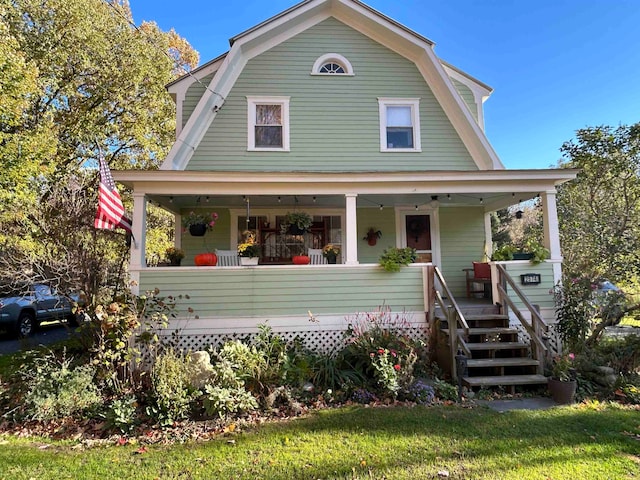 view of front of house with a porch, a front yard, and ceiling fan