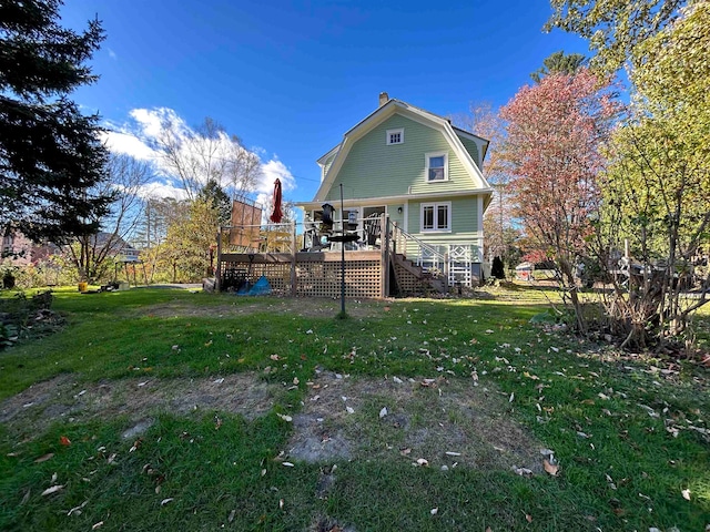 back of property featuring a wooden deck and a yard