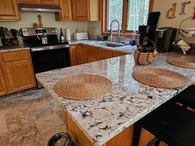 kitchen featuring kitchen peninsula, a kitchen breakfast bar, light stone countertops, electric stove, and sink