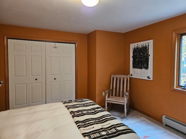 bedroom with a closet, baseboard heating, and carpet