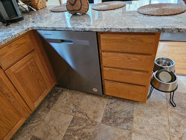 kitchen featuring dishwasher and light stone counters