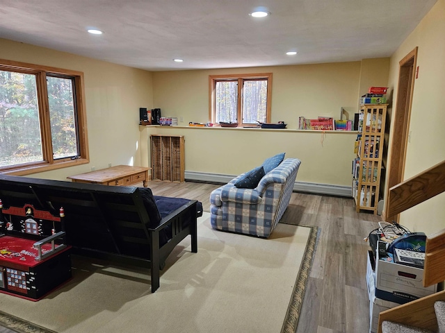 interior space featuring a baseboard heating unit, wood-type flooring, and plenty of natural light