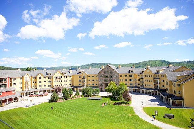 view of home's community with a mountain view and a lawn