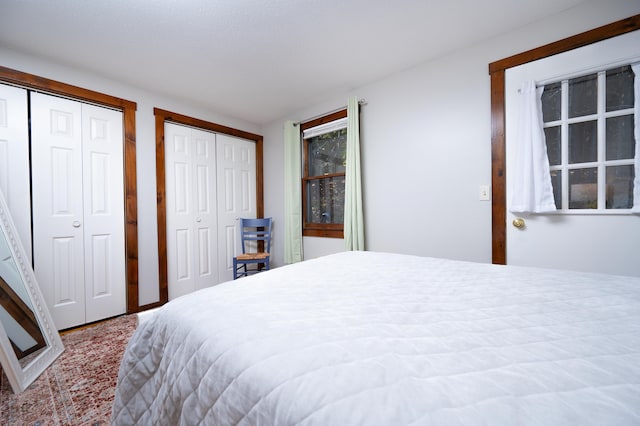 carpeted bedroom featuring two closets