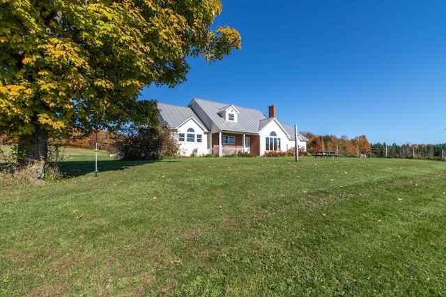 cape cod-style house with a front yard