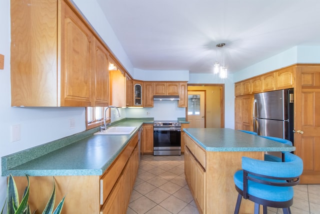 kitchen with a kitchen island, stainless steel appliances, sink, a breakfast bar, and light tile patterned floors