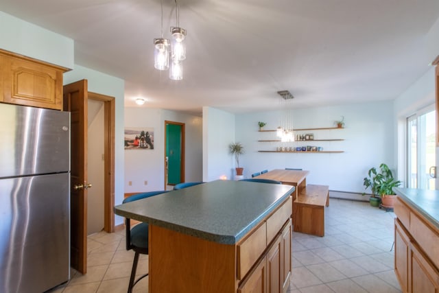 kitchen with decorative light fixtures, baseboard heating, a center island, and stainless steel refrigerator