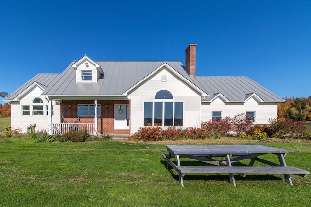 rear view of property featuring a yard and covered porch