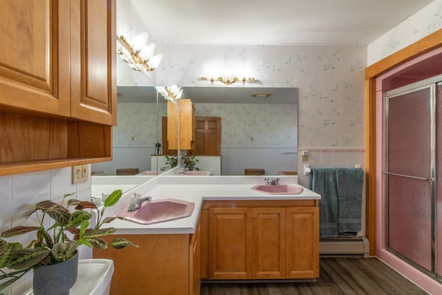 bathroom featuring vanity, walk in shower, baseboard heating, and hardwood / wood-style floors