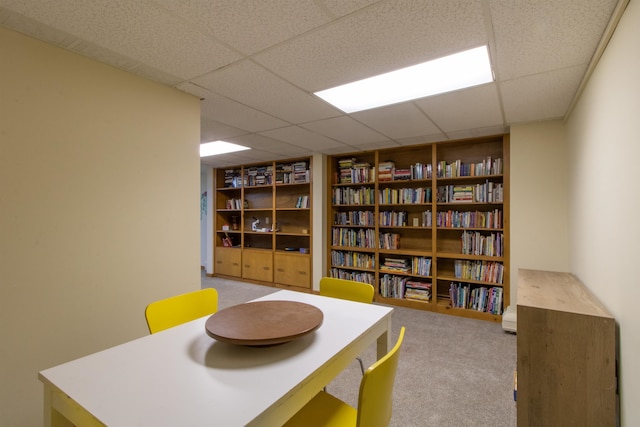 interior space featuring a paneled ceiling and light colored carpet