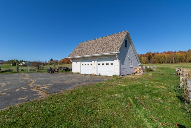 view of side of home featuring a yard and a garage