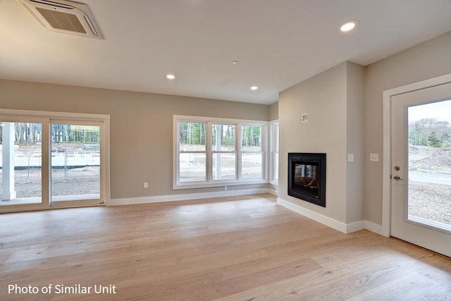 unfurnished living room with a wealth of natural light and light wood-type flooring