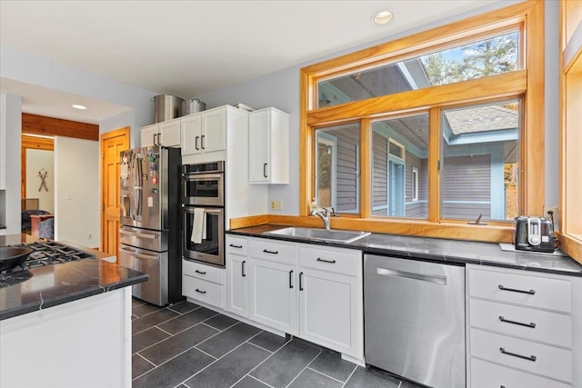 kitchen featuring sink, appliances with stainless steel finishes, and white cabinetry