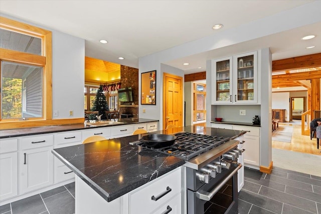 kitchen featuring high end stove, a kitchen island, white cabinets, and dark hardwood / wood-style floors