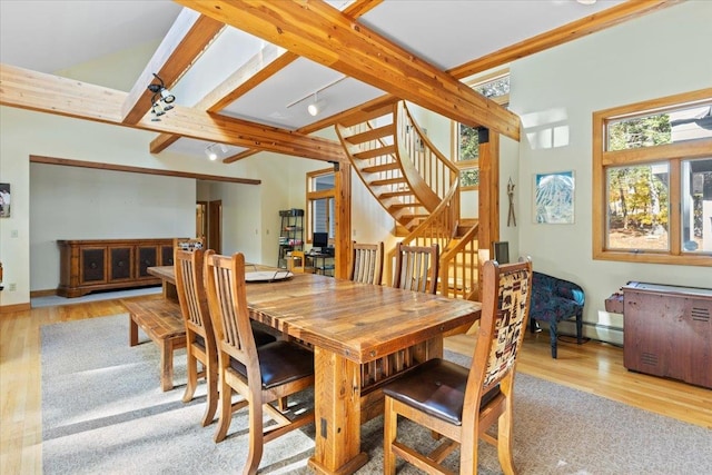 dining area featuring light hardwood / wood-style flooring, beam ceiling, and baseboard heating