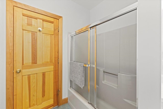 bathroom featuring combined bath / shower with glass door