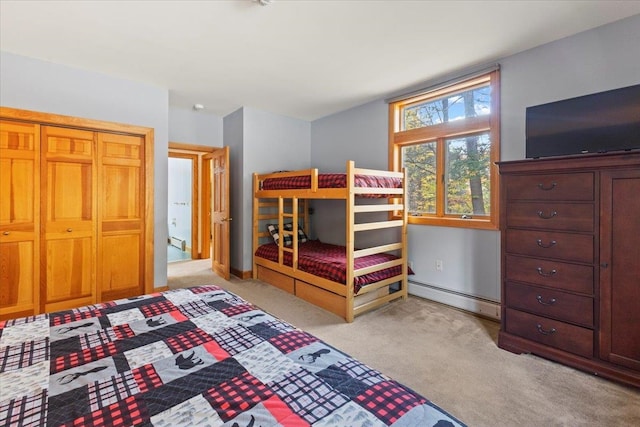 carpeted bedroom with a closet and baseboard heating