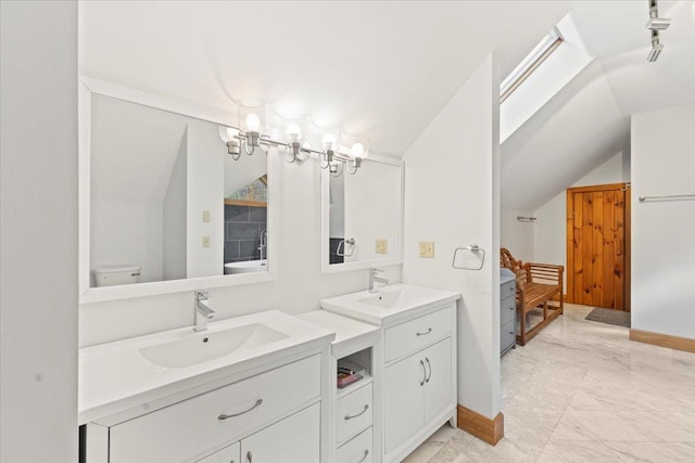 bathroom with toilet, lofted ceiling with skylight, and vanity