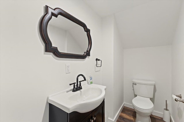 bathroom with toilet, vanity, and wood-type flooring