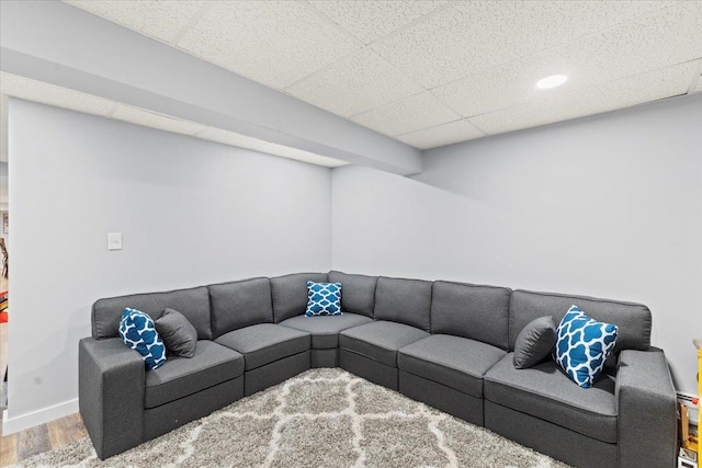 living room featuring a paneled ceiling and hardwood / wood-style floors