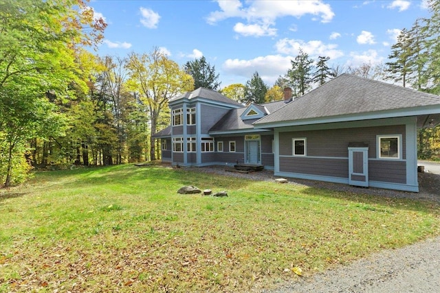 back of house with a sunroom and a lawn