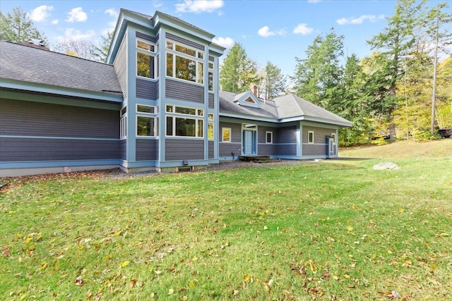 rear view of house featuring a yard