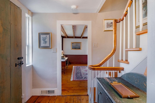 corridor featuring beam ceiling and dark hardwood / wood-style flooring
