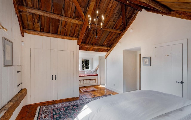 unfurnished bedroom featuring ensuite bathroom, beam ceiling, wooden ceiling, and wood-type flooring