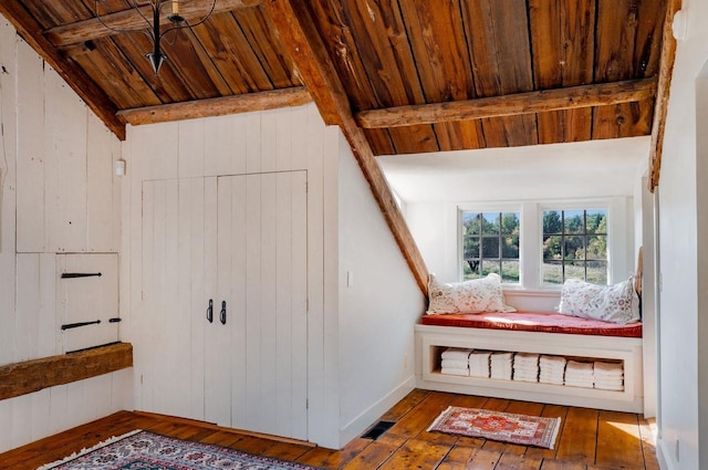 stairway with lofted ceiling with beams, wooden ceiling, wooden walls, and hardwood / wood-style floors