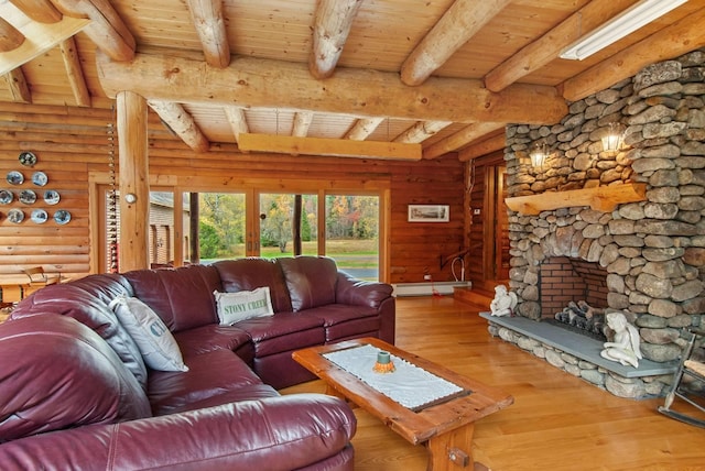 living room featuring beamed ceiling, a stone fireplace, wood ceiling, and wood-type flooring