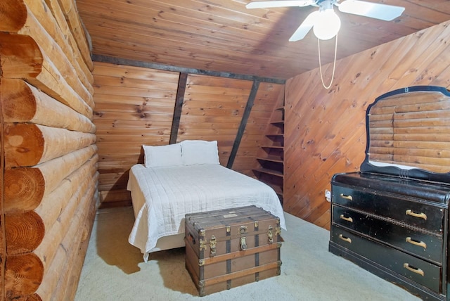 carpeted bedroom with wood walls, wooden ceiling, rustic walls, and ceiling fan