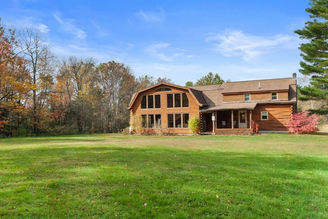 rear view of property featuring a lawn, log siding, and a gambrel roof