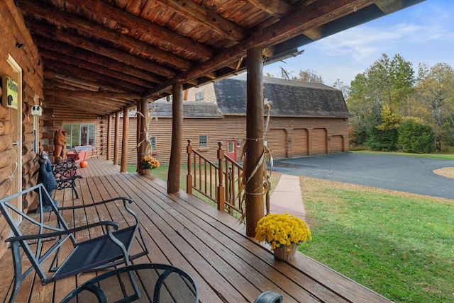 wooden terrace featuring a yard and a garage