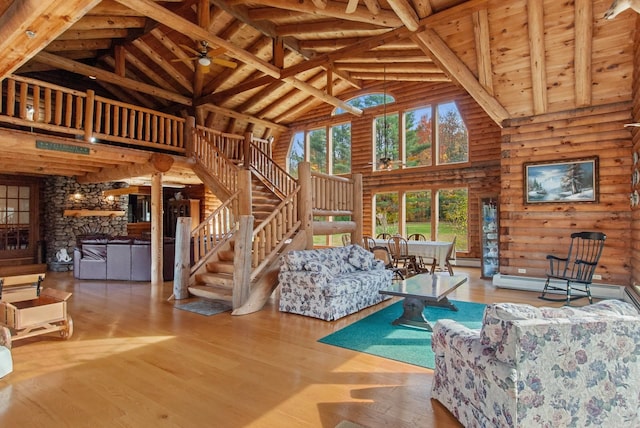 living room with hardwood / wood-style flooring, beamed ceiling, wooden ceiling, rustic walls, and high vaulted ceiling