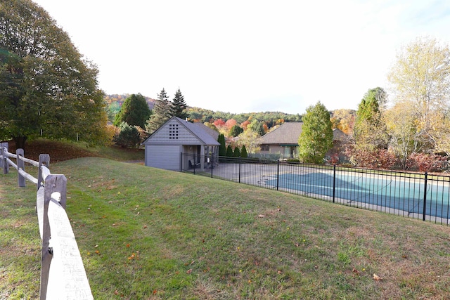 view of yard with a fenced in pool and a storage unit