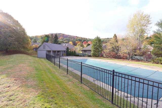 view of swimming pool featuring an outbuilding and a lawn