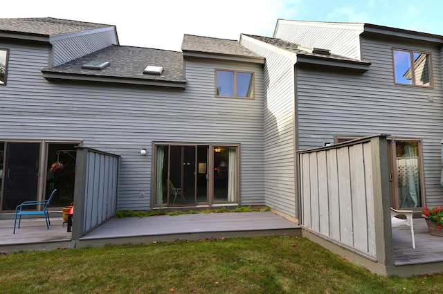 rear view of property with a yard and a deck