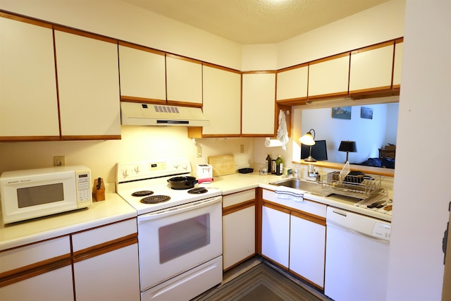 kitchen featuring white appliances, a textured ceiling, and sink