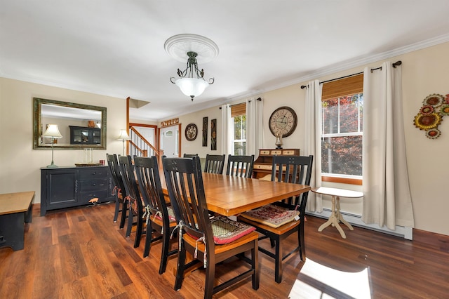 dining room featuring dark wood-type flooring, crown molding, and a baseboard heating unit