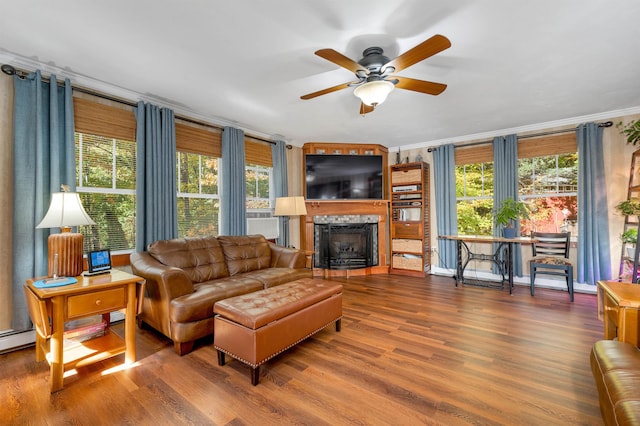 living room featuring wood-type flooring, ceiling fan, and ornamental molding