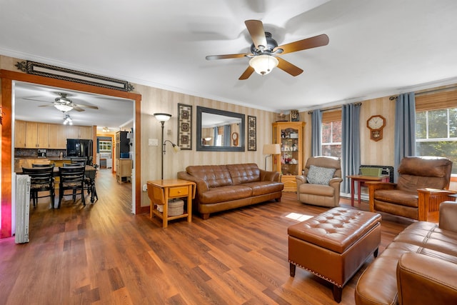 living room with hardwood / wood-style floors, ceiling fan, and crown molding