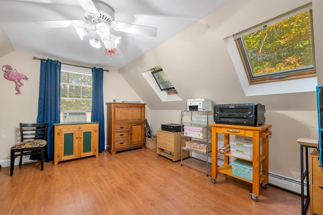 office space featuring vaulted ceiling with skylight, ceiling fan, and light hardwood / wood-style flooring