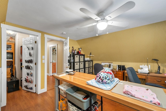 home office with light hardwood / wood-style floors and ceiling fan