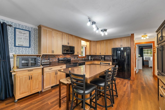 kitchen featuring a center island, light brown cabinets, tasteful backsplash, dark hardwood / wood-style floors, and black appliances