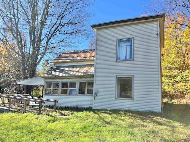 view of side of home with a yard