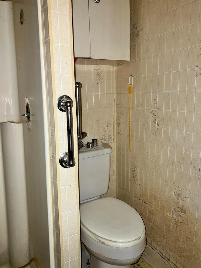 bathroom with tile walls, a shower, and toilet