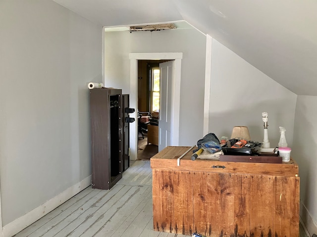 hallway featuring vaulted ceiling and light wood-type flooring